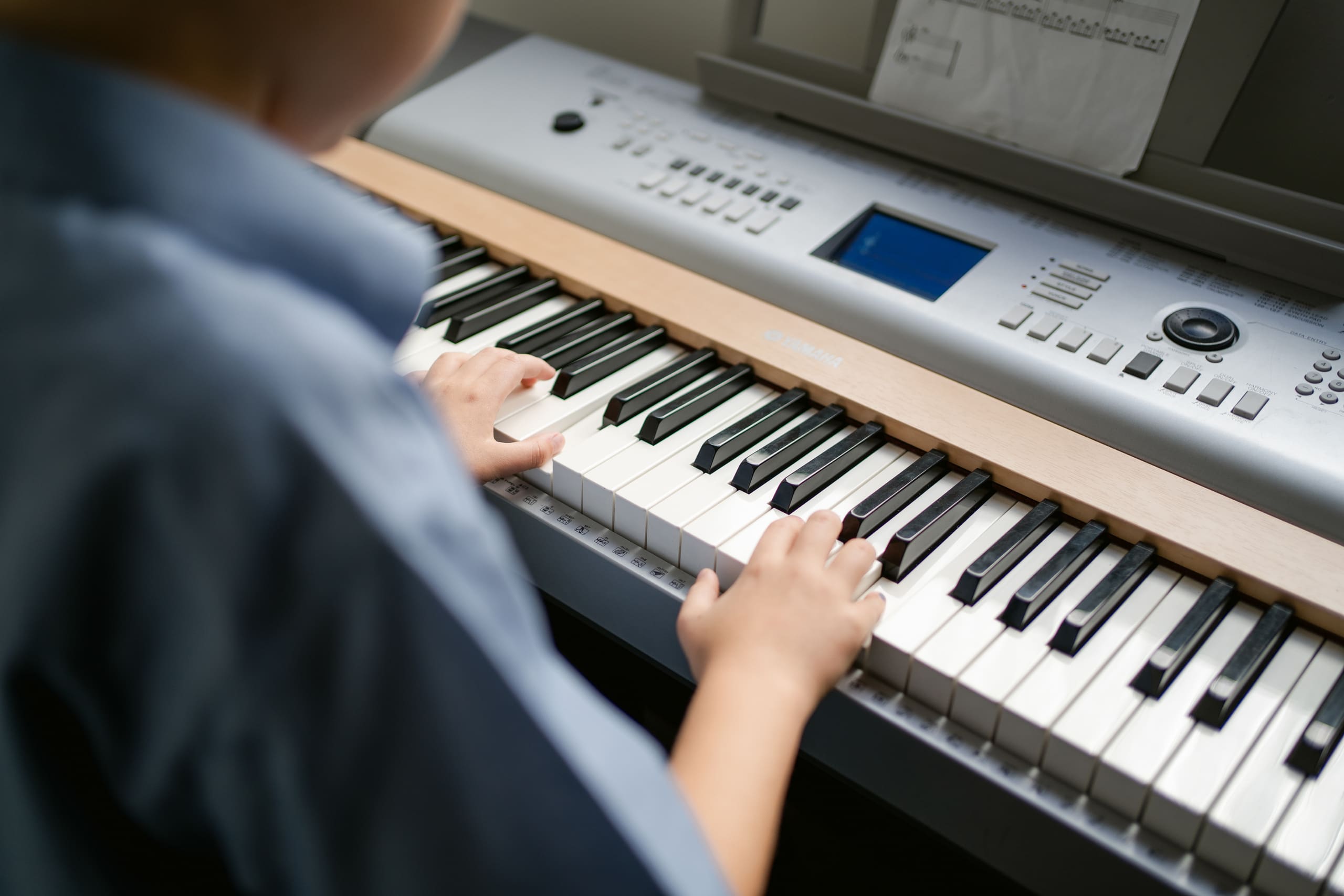 Close up of a student's hands playing the keyboard.