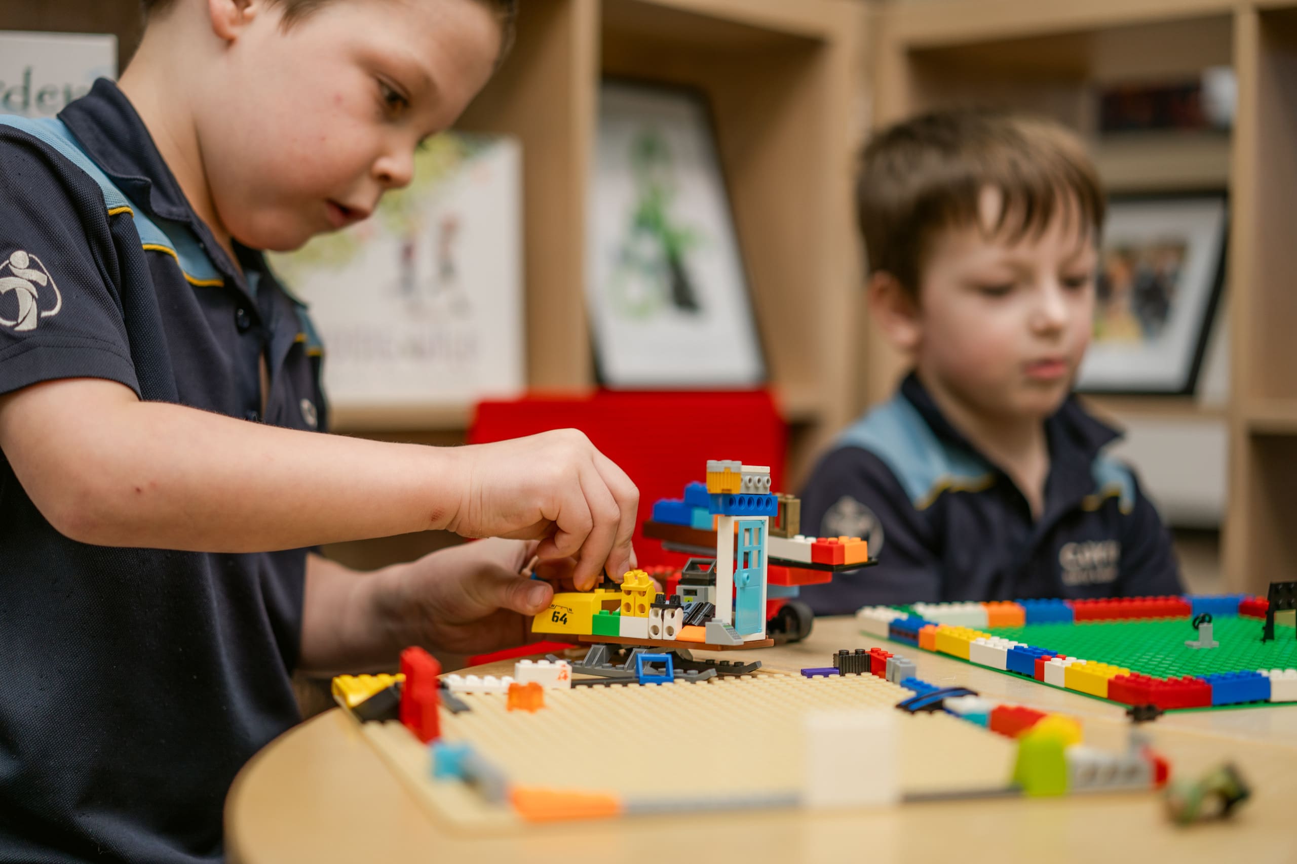 Close up of two students playing with Lego.