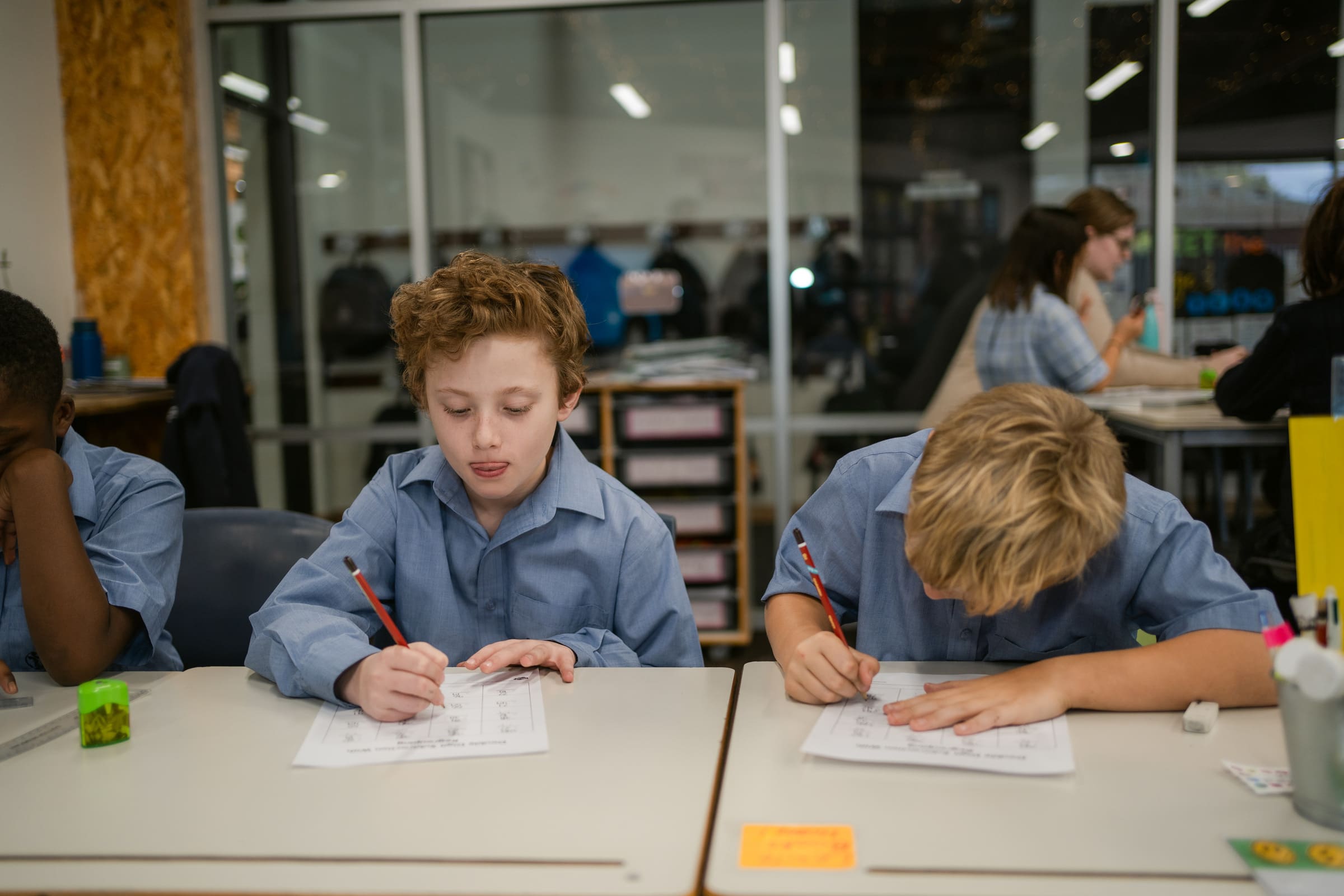 Two male students are working at their desk.